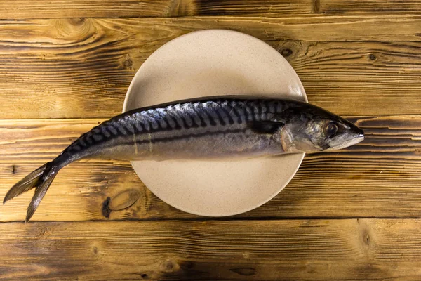 Соленая рыба-скимбер на тарелке. Целая скумбрия на деревянном столе — стоковое фото
