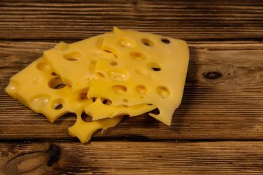 Ahşap masanın üzerine İsviçre peyniri dilimlenmiş