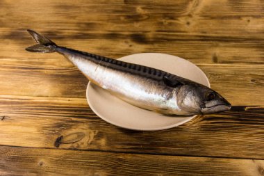 Scomber balık bir plaka üzerinde tuzlu. Ahşap masa üzerinde tüm uskumru