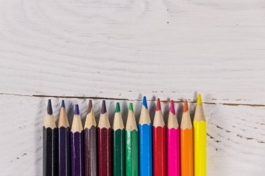 Beyaz ahşap masa üzerinde renkli kalemler. Üstten Görünüm, kopya alanı