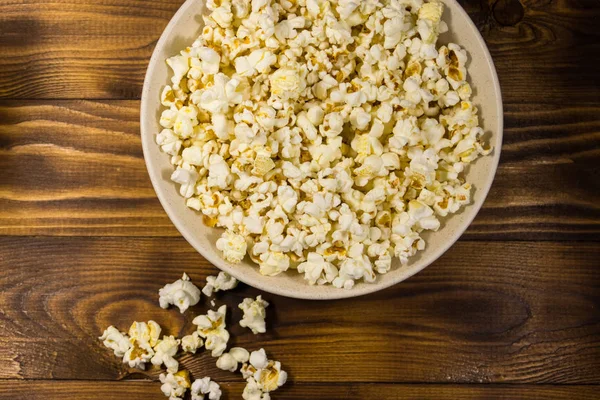 Bowl with popcorn on wooden table — Stock Photo, Image