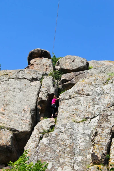 Menina escalador de rocha sobe em uma rocha — Fotografia de Stock
