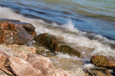 Kayaların üzerinden süzülen deniz dalgaları