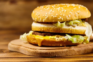Ahşap masada lezzetli büyük hamburger.