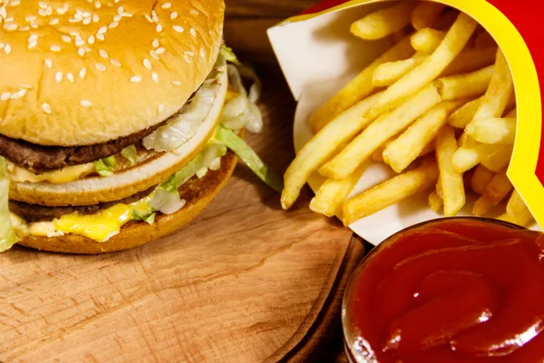 Nydelig hamburger med pommes frites og ketsjup på trebord. – stockfoto