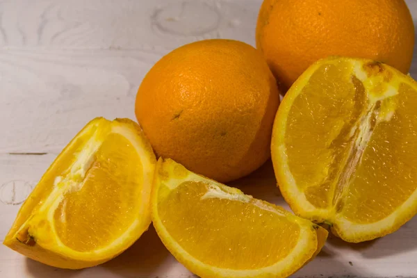 Beyaz ahşap masada taze portakallar.