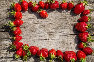 Çerçeve ahşap masa üzerinde taze kırmızı çilek 