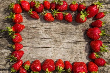 Çerçeve ahşap masa üzerinde taze kırmızı çilek 