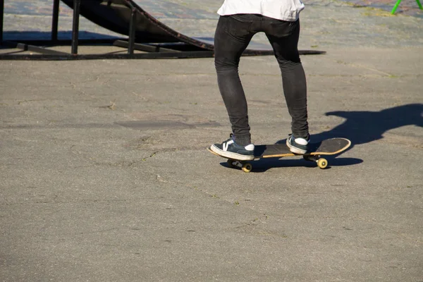 Gambe da skateboarder cavalcando skateboard allo skatepark — Foto Stock