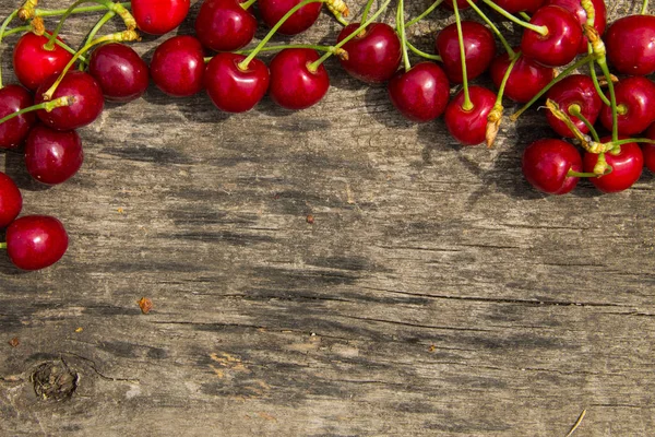 Röda körsbär frukter på trä bakgrund — Stockfoto