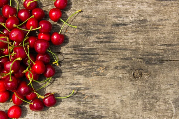 Röda körsbär frukter på trä bakgrund — Stockfoto