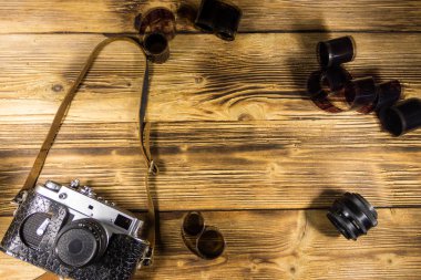 Ahşap masanın üzerinde fotoğraf makinesi ve lens olan eski fotoğraf makinesi.