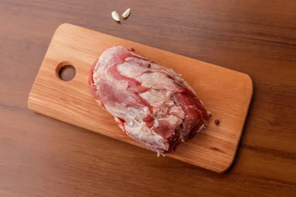 在桌子上的砧板上生猪肉。顶部视图 — 图库照片