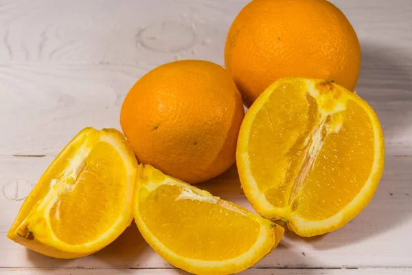 하얀 나무 탁자 위에 있는 신선 한 오렌지 — 스톡 사진