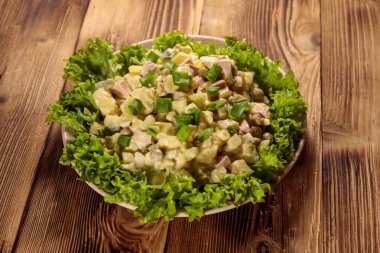 Geleneksel Rus şenlik salatası Olivier tahta masada.