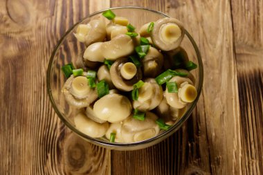 Cam kase salamura petrol ile. Ahşap masa üzerinde Marine mantar