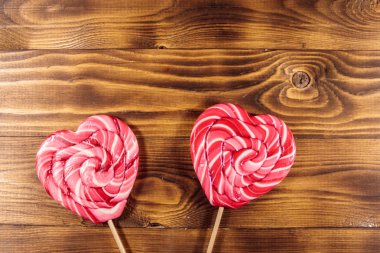 Lolipop ahşap arka plan üzerinde iki kalp şeklinde