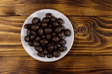 Ahşap masada çikolata ile kaplı fıstık