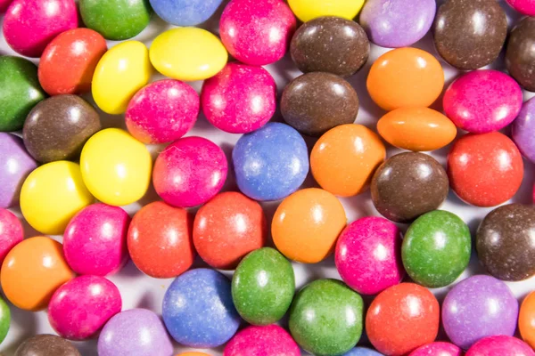 Fond des bonbons colorés en forme de bouton remplis de chocolat — Photo