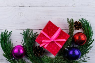 Noel kompozisyonu köknar ağacı dalları, hediye kutusu ve beyaz ahşap masada Noel süslemeleri. Üst görünüm, alanı kopyala