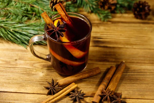 Vin chaud de Noël aux épices et branches de sapin et cônes sur table en bois — Photo