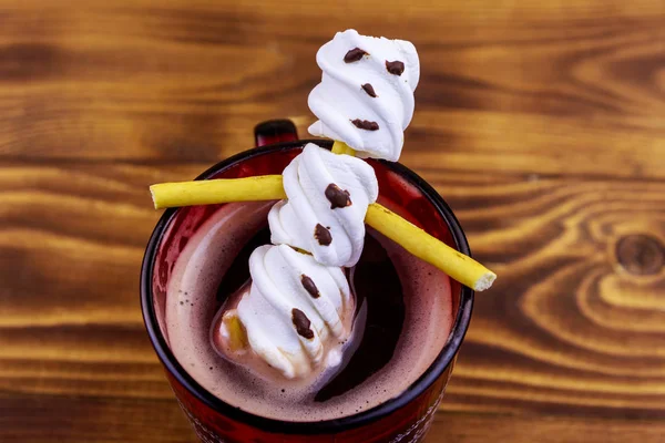 Homem de neve de marshmallow derretido em uma xícara de chocolate quente na mesa de madeira — Fotografia de Stock