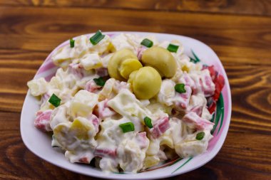 Ahşap masada marine mantar, sosis, soğan ve mayonez ile patates salatası