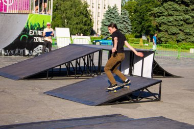 Kaykaycı kaykay parkında bir numara yapıyor.