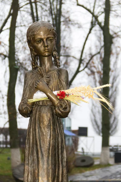 Escultura de una joven hambrienta con espigas de trigo en las manos — Foto de Stock