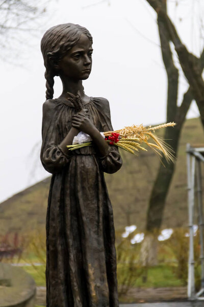 Sculpture of hungry young girl with ears of wheat in their hands