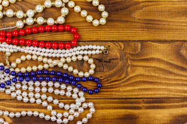 Ahşap arka planda farklı boncuk kolyeler