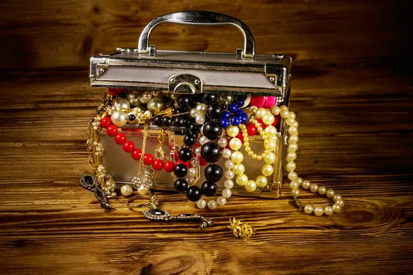 Portagioie pieno di gioielli e accessori su sfondo di legno — Foto Stock
