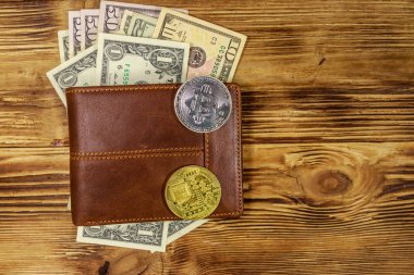 Ahşap arka plan üzerinde Amerikan doları banknotlar ve bitcoins ile Cüzdan