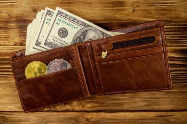 Ahşap arka plan üzerinde Amerikan yüz dolar faturaları ve bitcoins ile Cüzdan