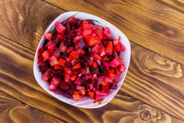 Vinagreta tradicional de ensalada rusa con remolacha, zanahoria, papa, cebolla y pepinos en escabeche sobre mesa de madera. Vista superior —  Fotos de Stock