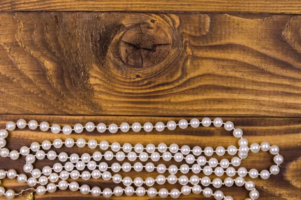 Perlový náhrdelník na dřevěném pozadí. Horní pohled, kopírovací prostor — Stock fotografie