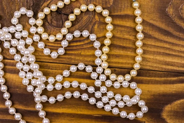 Collar de perlas sobre fondo de madera. Vista superior — Foto de Stock