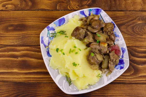 Puré de papas con hígado de pollo guisado con manzana y cebolla sobre mesa de madera —  Fotos de Stock