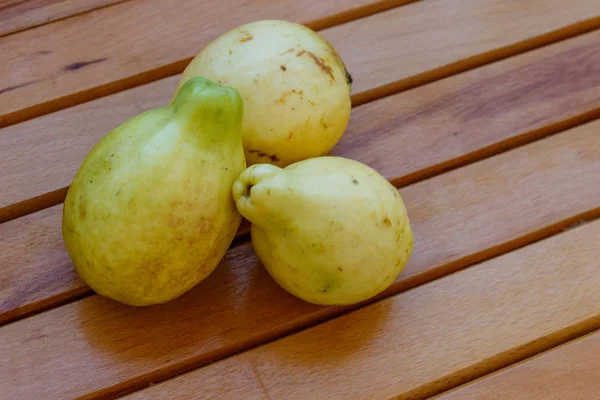 Ahşap masada bütün guava meyveleri — Stok fotoğraf