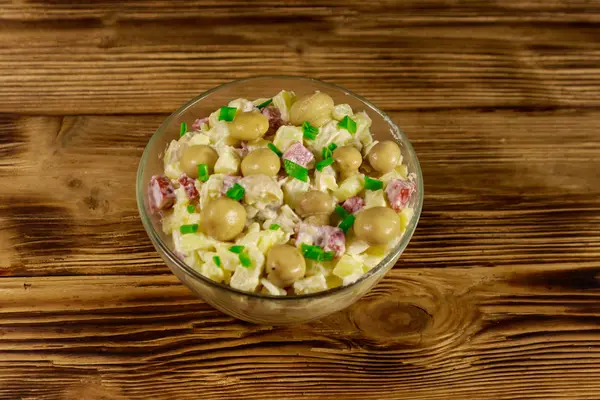 Salată de cartofi cu ciuperci marinate, cârnați, ceapă și maioneză pe masă de lemn — Fotografie, imagine de stoc