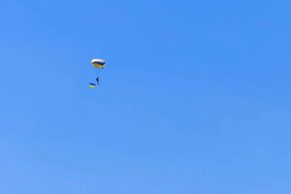 Paracaidista llevando bandera de Ucrania en el cielo azul claro —  Fotos de Stock