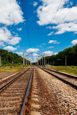 Kırsal alanda doğal demiryolu ve yaz aylarında beyaz bulutlar ile mavi gökyüzü