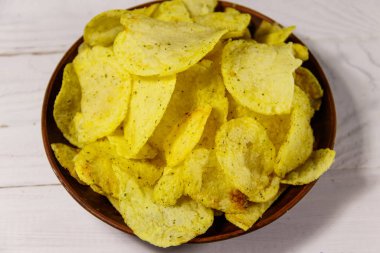 Beyaz ahşap masada patates cipsi tabağı