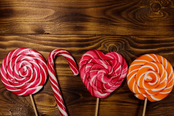 Sweet lollipops on rustic wooden background. Top view — Stock Photo, Image