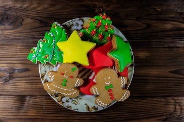 Noel ağacı şeklinde lezzetli Noel kurabiyeleri, zencefilli kurabiye, yıldız ve Noel çoraplı tahta masa. Üst görünüm