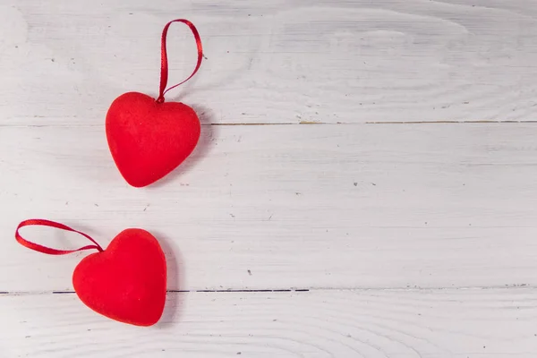 Dos corazones rojos sobre fondo blanco de madera — Foto de Stock