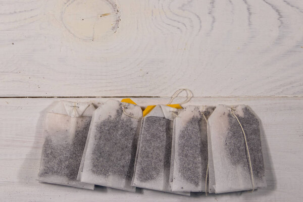 Пакеты чая на белом деревянном столе. Вид сверху
