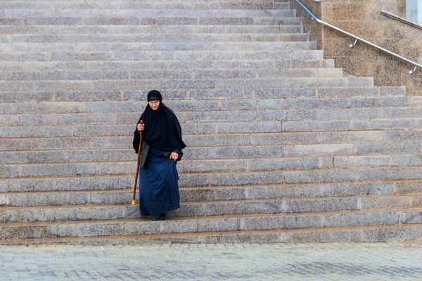 Пожилая православная монахиня спускается по лестнице из собора — стоковое фото