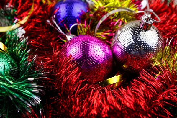 Composición navideña con adornos navideños y oropel multicolor. Bolas de Navidad en brillante oropel primer plano —  Fotos de Stock