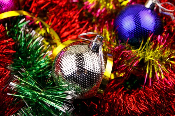 Kerstcompositie met kerstballen en veelkleurig knutselwerk. Kerstballen in helder tinsel close-up — Stockfoto